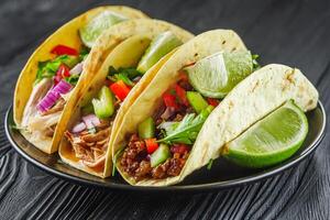 set of delicious juicy tacos on black wooden rustic background photo