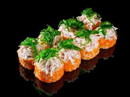 sushi roll with crab tobiko cucumber cream chukka cheese on a black mirror background photo