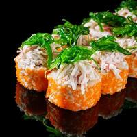 sushi roll with crab tobiko cucumber cream chukka cheese on a black mirror background photo