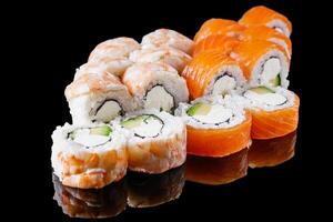 sushi roll with shrimp Ebby cream cheese Philadelphia avocado cucumber on a black mirror background photo