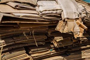 Stack of corrugated paper waste before sending to shred and recycle at recycling plant. Corrugated fiberboard. Old, randomly folded paper. photo