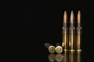 Bullet isolated on black background with reflexion. Rifle bullets close-up on black back. Cartridges for rifle and carbine on a black. photo