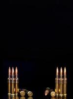 Bullet isolated on black background with reflexion. Rifle bullets close-up on black back. Cartridges for rifle and carbine on a black. photo