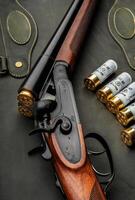 Classic trigger double-barreled hunting rifle on a green background. Smooth-bore hunting rifle open for reloading. Concept postcards for hunters. photo