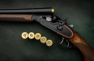 Classic trigger double-barreled hunting rifle on a green background. Smooth-bore hunting rifle open for reloading. Concept postcards for hunters. photo