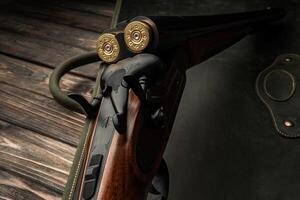 Classic trigger double-barreled hunting rifle on a green back. Smooth-bore hunting rifle open for reloading. Concept postcards for hunters. photo