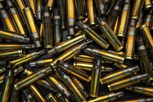 Background from empty cartridges for rifles and carbines. Shiny brass shells scattered on the surface. photo