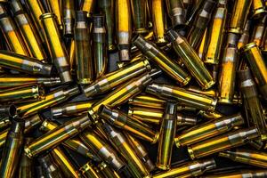 Background from empty cartridges for rifles and carbines. Shiny brass shells scattered on the surface. photo