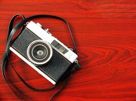 old vintage camera gear on wooden table background. top view, flat lay. Retro vintage concept. Travel and journey design element photo
