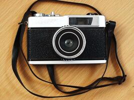 old vintage camera gear on wooden table background. top view, flat lay. Retro vintage concept. Travel and journey design element photo