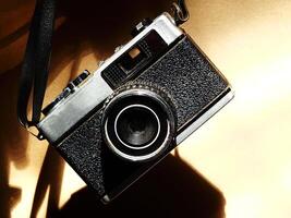 old vintage camera gear hanging with drop shadow background. Available light. Retro vintage concept. Travel and journey design element photo
