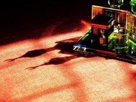Small model of the Kaaba, the holy mosque of the Grand Mosque, Mecca, isolated on a dark background. There is sunlight coming performing an amazing shadow and shining reflection photo