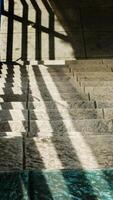 Abstract background texture of a staircase with a geometric shadow cast on it. The shadow is on the steps and the steps are grey photo