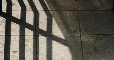 Abstract background texture of a staircase with a geometric shadow cast on it. The shadow is on the steps and the steps are grey photo