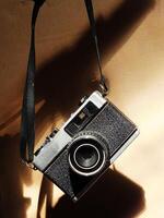 old vintage camera gear hanging with drop shadow background. Available light. Retro vintage concept. Travel and journey design element photo