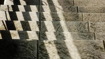 Abstract background texture of a staircase with a geometric shadow cast on it. The shadow is on the steps and the steps are grey photo