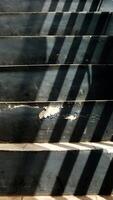 Abstract background texture of a staircase with a geometric shadow cast on it. The shadow is on the steps and the steps are grey photo