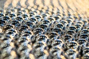Close-up of metal balls in the field of sharpness. Blurred background with pronounced bokeh. photo
