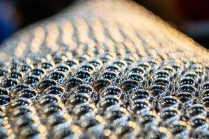 Close-up of metal balls in the field of sharpness. Blurred background with pronounced bokeh. photo