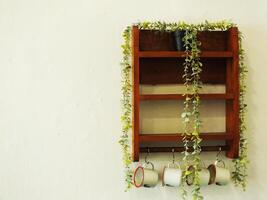 Retro vintage interior design. Wooden shelves with artificial plants, vintage enamel cup. Copy space for text message photo