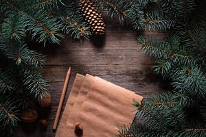 Christmas frame from fir branches on a background of an old gray board around an open notebook with blank sheets. Frame of fir branches. Christmas card blank concept. photo