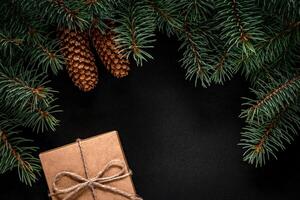 A frame of fir branches and gift paper box tied with twine. Christmas card blank. photo