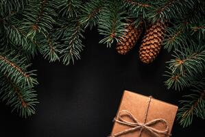 A frame of fir branches and gift paper box tied with twine. Christmas card blank. photo