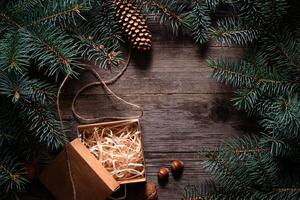 A frame of fir branches and an open gift paper box tied with twine. Christmas card blank. photo