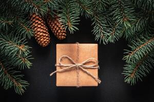 A frame of fir branches and gift paper box tied with twine. Christmas card blank. photo