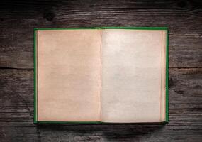 Vintage book, open, on old wooden table, with clipping path. Open Book blank on old wooden background. book with blank pages photo