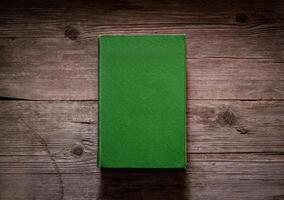 Closed book on vintage wooden background. Old book on the wooden table. Closed book with empty cover laying on wooden table. photo