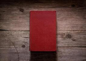 Closed book on vintage wooden background. Old book on the wooden table. Closed book with empty cover laying on wooden table. photo