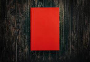 Closed book on vintage wooden background. Book on the wooden table. Closed book with empty cover laying on wooden table. photo