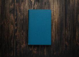 Closed book on vintage wooden background. Old book on the wooden table. Closed book with empty cover laying on wooden table. photo