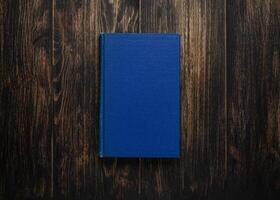 Closed book on vintage wooden background. Old book on the wooden table. Closed book with empty cover laying on wooden table. photo