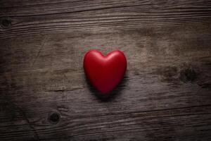 Red heart on vintage wooden background. Valentine day concept. Top view red heart on old wood texture background with copy space for text. photo