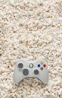 White gamepad on popcorn back. Game poster or postcard concept. Rest for the game and popcorn. photo