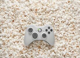 White gamepad on popcorn back. Game poster or postcard concept. Rest for the game and popcorn. photo