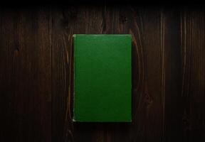 Closed book on vintage wooden background. Old book on the wooden table. Closed book with empty cover laying on wooden table. photo
