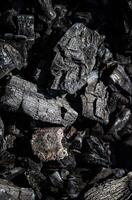 Ash of a burned-out fire. Background of burnt firewood. Background with black burnt wood. Charcoal texture backdrop. Bonfire covered with ashes and sawdust closeup photo