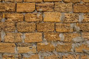 Brick wall of yellow shell rock. Closeup of shellstone texture. Background wall with shell rock. Old wall. Texture limestone photo