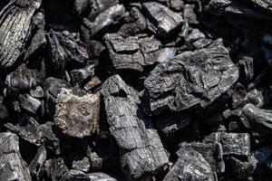 Ash of a burned-out fire. Background of burnt firewood. Background with black burnt wood. Charcoal texture backdrop. Bonfire covered with ashes and sawdust closeup photo