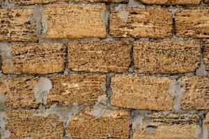Brick wall of yellow shell rock. Closeup of shellstone texture. Background wall with shell rock. Old wall. Texture limestone photo