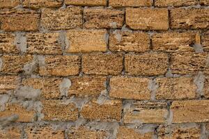 Brick wall of yellow shell rock. Closeup of shellstone texture. Background wall with shell rock. Old wall. Texture limestone photo