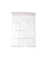 Patches for cleaning weapons isolate on a white back. White square scraps of fabric stacked in a pile and packed in a plastic bag. photo
