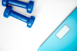 scales and dumbbells on a white photo