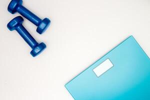 scales and dumbbells on a white photo