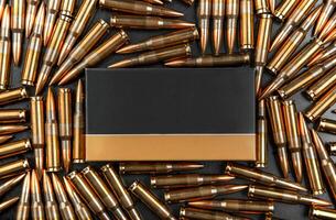 Background from rifle cartridges on a gray metal back. A box of cartridges. Copy space for text in the center of the image in the form of a rectangle. photo