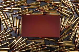 Background from rifle cartridges on a gray metal back. A box of cartridges. Copy space for text in the center of the image in the form of a rectangle. photo