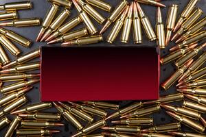 Background from rifle cartridges on a gray metal back. A box of cartridges. Copy space for text in the center of the image in the form of a rectangle. photo